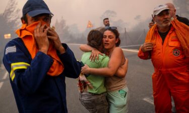 Emergency service personnel work to rescue people during wildfires in Varnavas