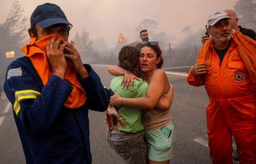 Emergency service personnel work to rescue people during wildfires in Varnavas