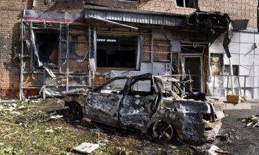 A burned car is seen in front of an apartment building damaged after shelling by the Ukrainian side in Kursk