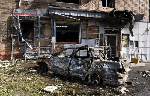 A burned car is seen in front of an apartment building damaged after shelling by the Ukrainian side in Kursk