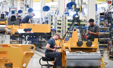 Workers are seen on an assembly line for compactors at Volvo Construction Equipment plant on June 6