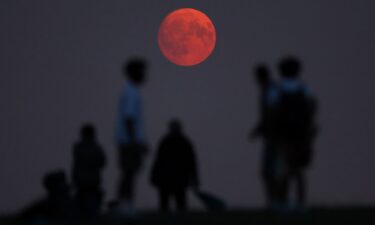 People view the moon as it rises