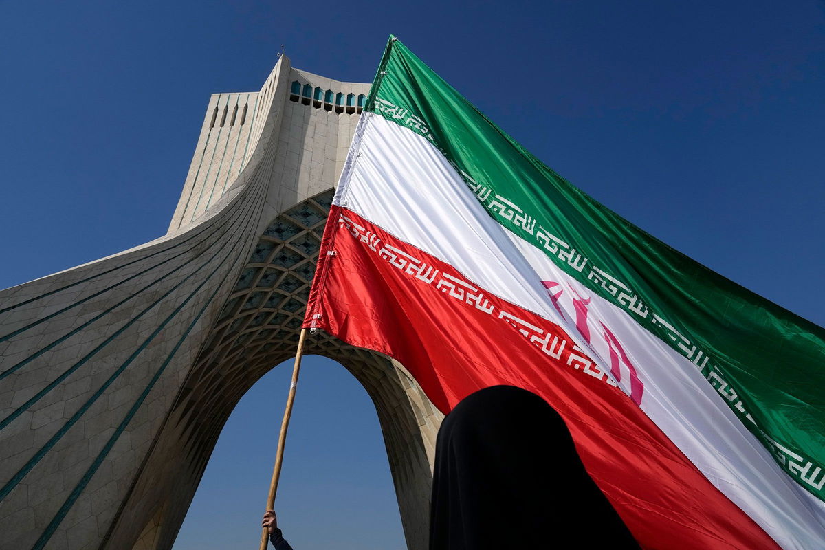 <i>Vahid Salemi/AP/File via CNN Newsource</i><br/>An Iranian flag is carried under the Azadi (Freedom) monument tower during the annual rally commemorating Iran's 1979 Islamic Revolution in Tehran in February.