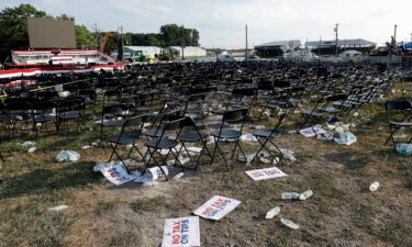 Campaign signs and empty water bottles are seen on the ground of former President Donald Trump's rally on July 13