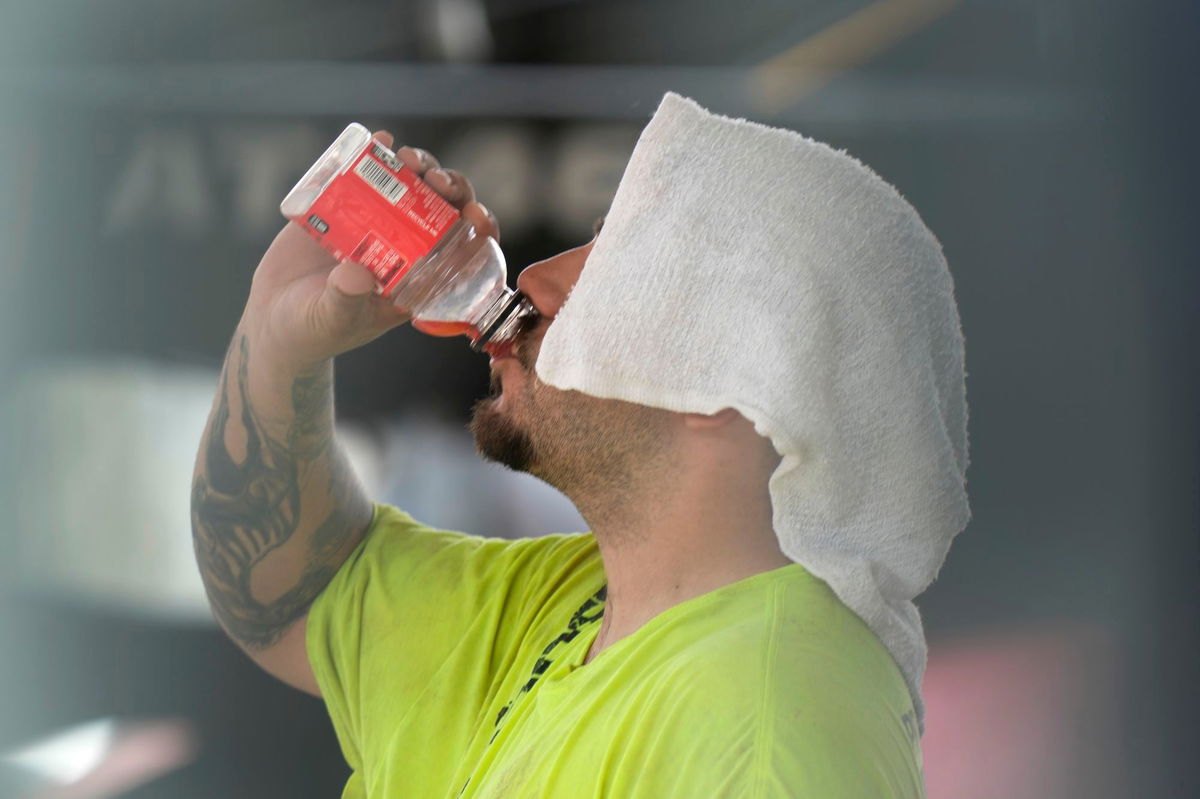 <i>Charles Rex Arbogast/AP via CNN Newsource</i><br/>A construction worker hydrates at the Shedd Aquarium Tuesday