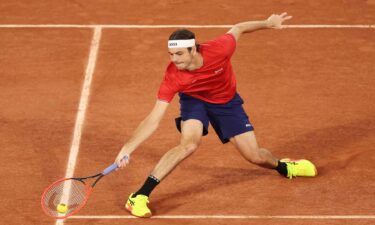 Taylor Fritz of the United States stretches for a forehand against Alexander Bublik of Kazakhstan during the men's singles first round match on day one of the Paris Olympics at Roland Garros on July 27