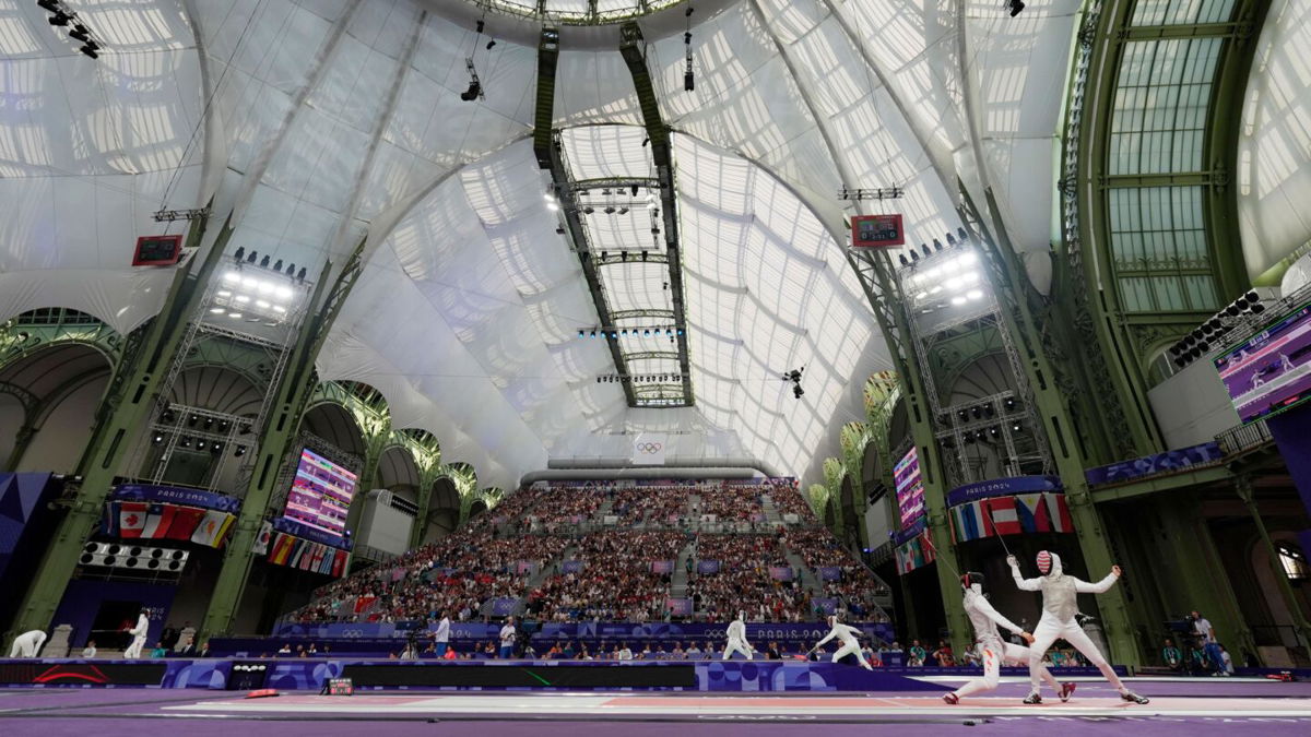 Lee Kiefer (USA) competes against Qianqian Huang (CHN) in a women's team foil table of 8 during the Paris Olympic Games at Grand Palais.