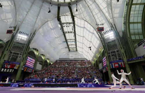 Lee Kiefer (USA) competes against Qianqian Huang (CHN) in a women's team foil table of 8 during the Paris Olympic Games at Grand Palais.