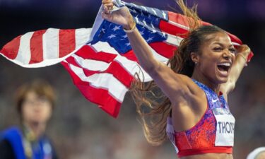 Gabby Thomas holds USA flag