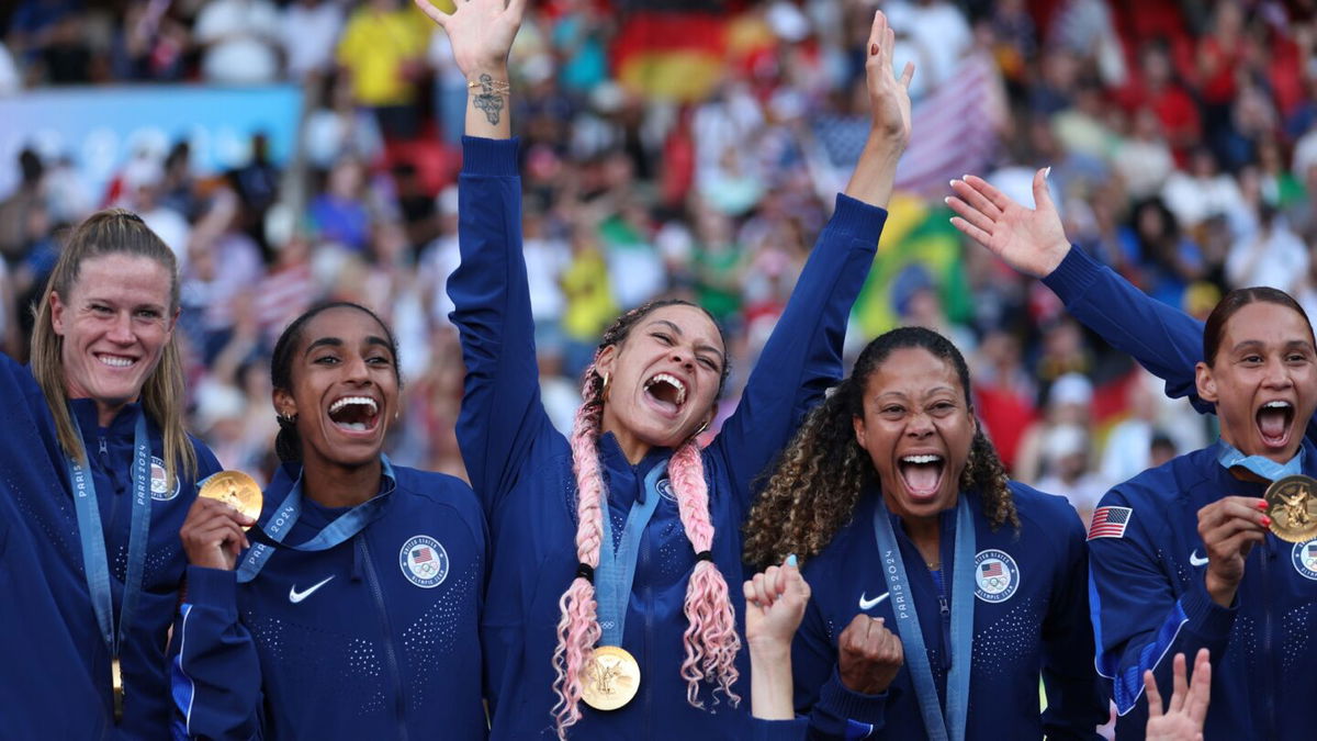 Members of the USWNT proudly show off their gold medals.