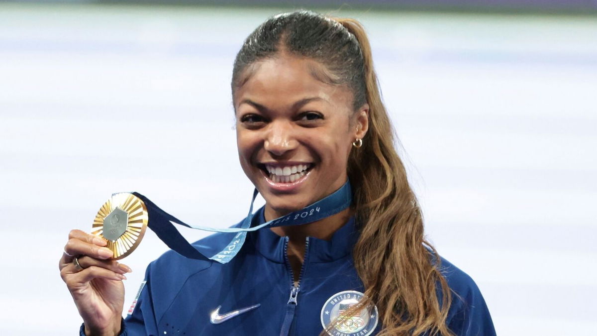 Gabby Thomas holds up gold Olympic medal