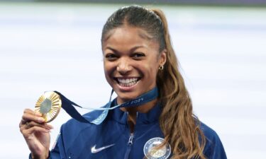 Gabby Thomas holds up gold Olympic medal