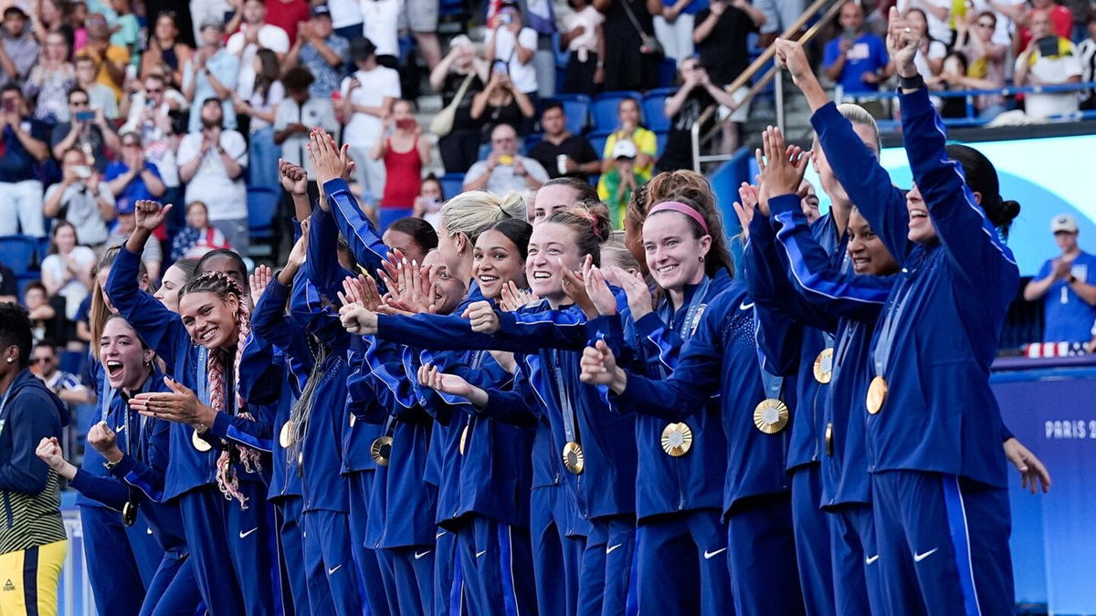 USWNT players pose with their medals.