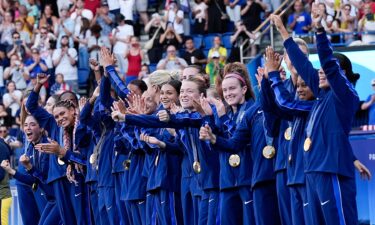 USWNT players pose with their medals.