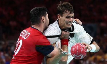 Two handball athletes contest for the ball.