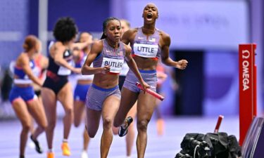 Aaliyah Butler of Team United States receives the baton from Shamier Little during the women's 4 x 400m relay round 1 at the Stade de France.