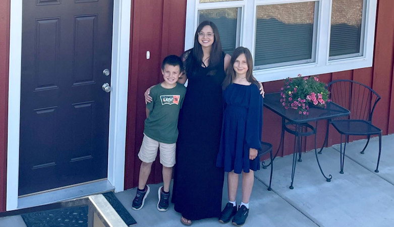 Ashley and family stand outside Bend Habitat home