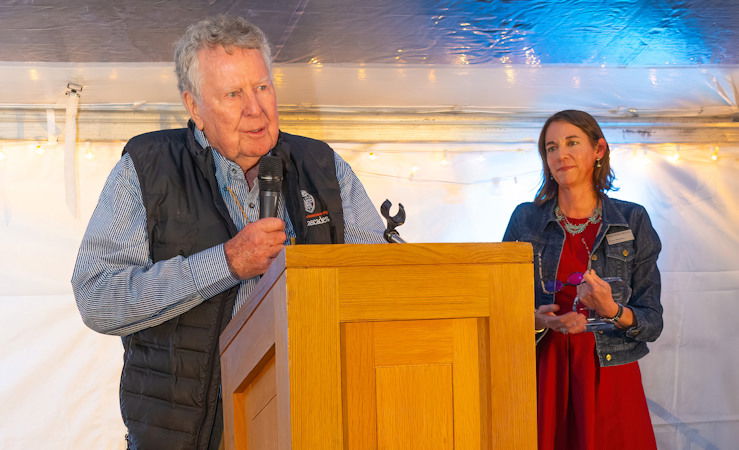 Michael P. Hollern, a trustee of The Bend Foundation, speaks at the 2024 High Desert Rendezvous while High Desert Museum Executive Director Dana Whitelaw looks on.