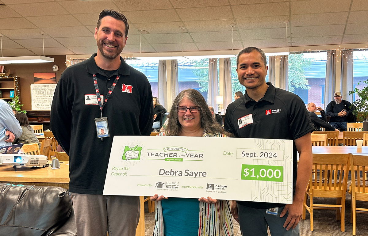 High Desert Regional Teacher of the Year Debra Sayre, flanked by Chris Haskell and Anthony Camacho of the Oregon Lottery.