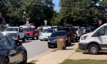 A line of cars park about half a mile from Apalachee High School.