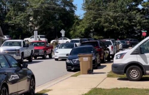 A line of cars park about half a mile from Apalachee High School.