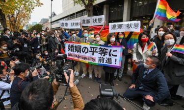 Plaintiffs and supporters react in front of the Tokyo District Court on November 30