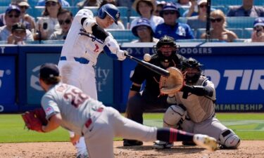 Los Angeles Dodgers' Shohei Ohtani hits a solo home run as Cleveland Guardians starting pitcher Tanner Bibee watches along.