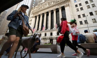 People walk past the New York Stock Exchange along Broad Street.