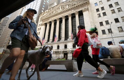 People walk past the New York Stock Exchange along Broad Street.