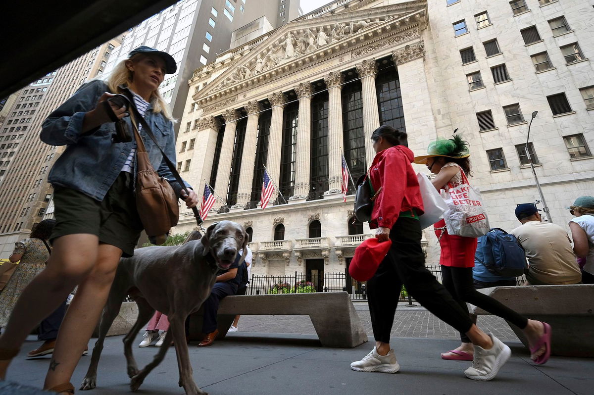 <i>Anthony Behar/Sipa USA/AP via CNN Newsource</i><br/>People walk past the New York Stock Exchange along Broad Street.