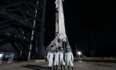 The Polaris Dawn crew poses in front of the Falcon 9 rocket and Crew Dragon spacecraft at launchpad 39A at Kennedy Space Center.