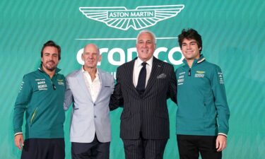 Aston Martin drivers Fernando Alonso (left) and Lance Stroll (right) with Adrian Newey (center left)