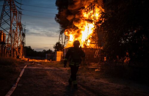 A Ukrainian firefighter talks on the radio while he works to extinguish the fire on the site of an electrical substation that was hit by Russian strike in Dnipropetrovsk region