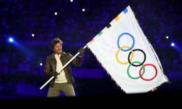 Tom Cruise holds the Olympic flag during the Closing Ceremony of the Olympic Games Paris 2024 at Stade de France on August 11.