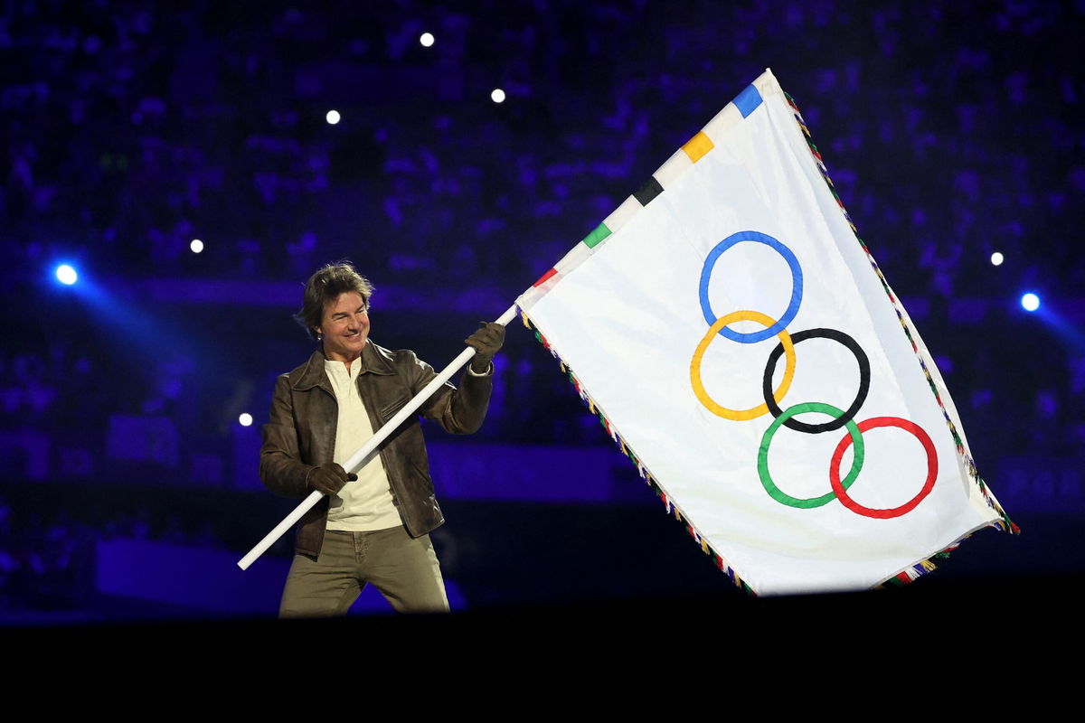 <i>Fabrizio Bensch/Pool/Getty Images via CNN Newsource</i><br/>Tom Cruise holds the Olympic flag during the Closing Ceremony of the Olympic Games Paris 2024 at Stade de France on August 11.