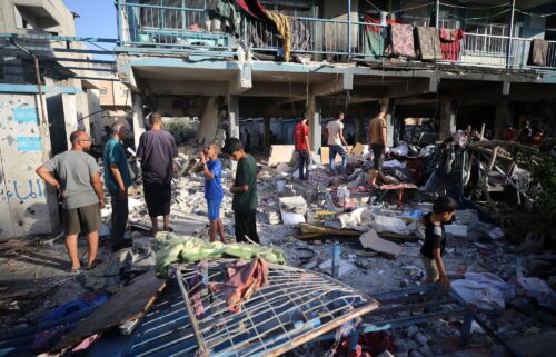 Palestinians check the grounds of a school after an Israeli airstrike in Nuseirat