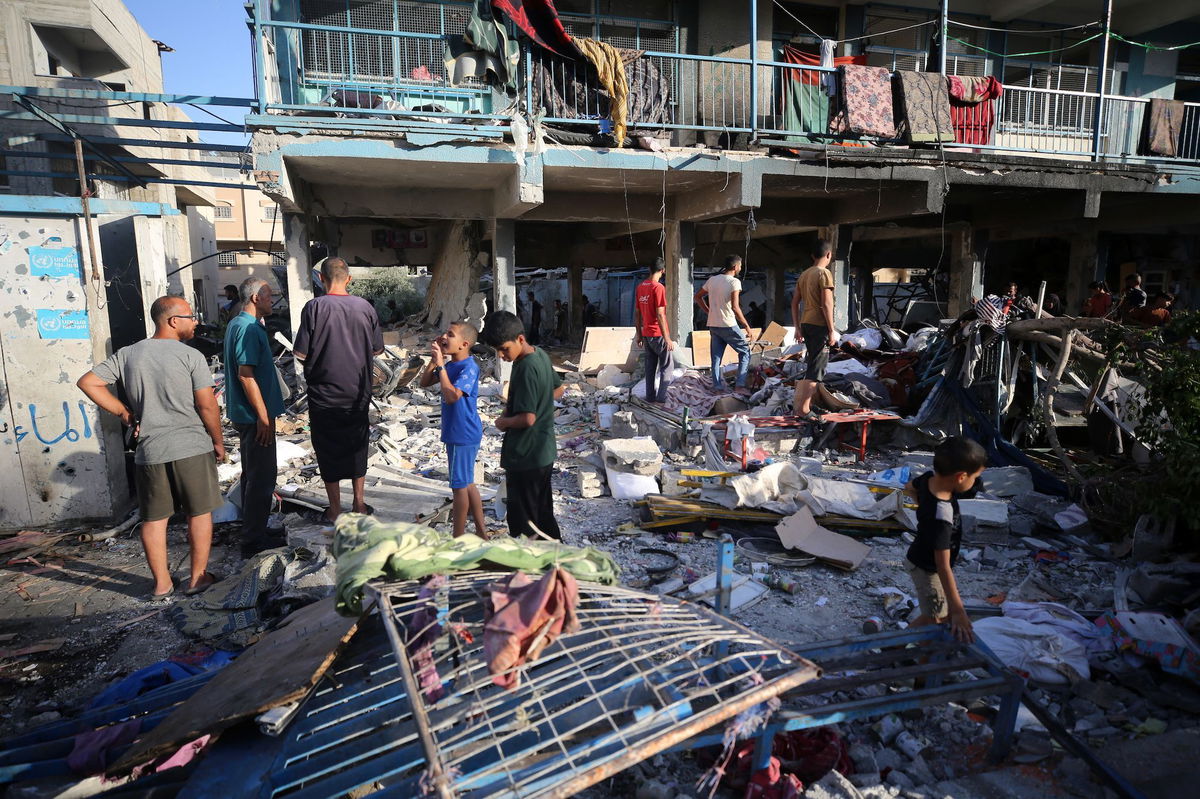 <i>Majdi Fathi/NurPhoto/Getty Images via CNN Newsource</i><br/>Palestinians check the grounds of a school after an Israeli airstrike in Nuseirat