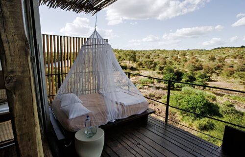 A mosquito net hanging over a day bed on the viewing deck of a luxury cliffside suite in South Africa.