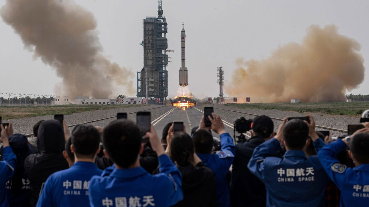 <i>Kevin Frayer/Getty Images via CNN Newsource</i><br/>A crowd watches three astronauts blast off onboard the Long March-2F at China's Jiuquan Satellite Launch Center on May 30