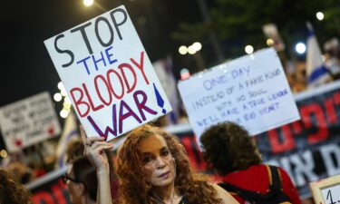 Demonstrators lift placards and flags during a protest calling for the release of Israelis held hostage by Hamas militants