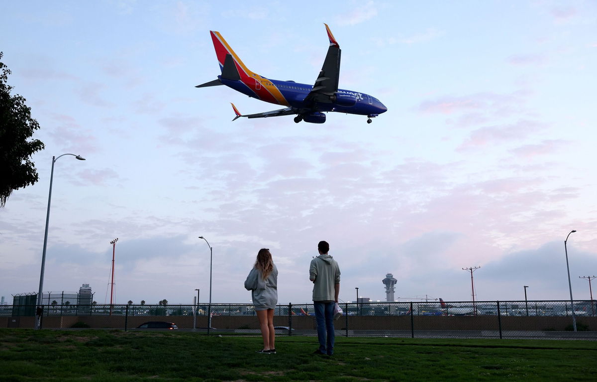 <i>Mario Tama/Getty Images/File via CNN Newsource</i><br/>People view a Southwest Airlines plane landing from a park next to Los Angeles International Airport. For a limited time