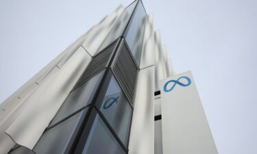 A security guard stands next to a sign at Meta headquarters in February 2023 in Menlo Park