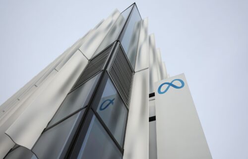 A security guard stands next to a sign at Meta headquarters in February 2023 in Menlo Park