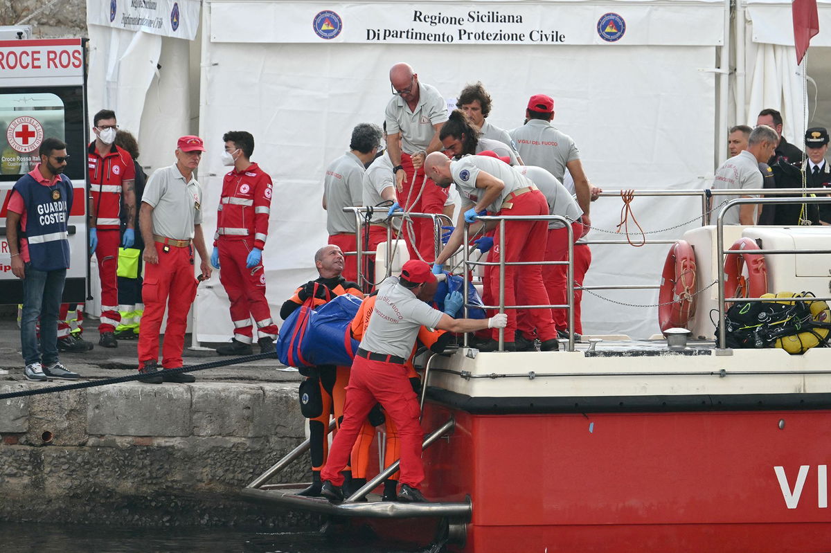 <i>Alberto Pizzoli/AFP/Getty Images via CNN Newsource</i><br/>Rescuers carry a body after divers return to Porticello harbor near Palermo