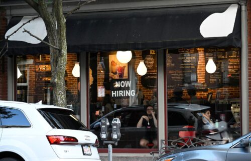 A "Now Hiring" sign advertising job openings is viewed in the window of a cafe on July 8 in Boston. Even though the unemployment rate edged lower last month to 4.2%