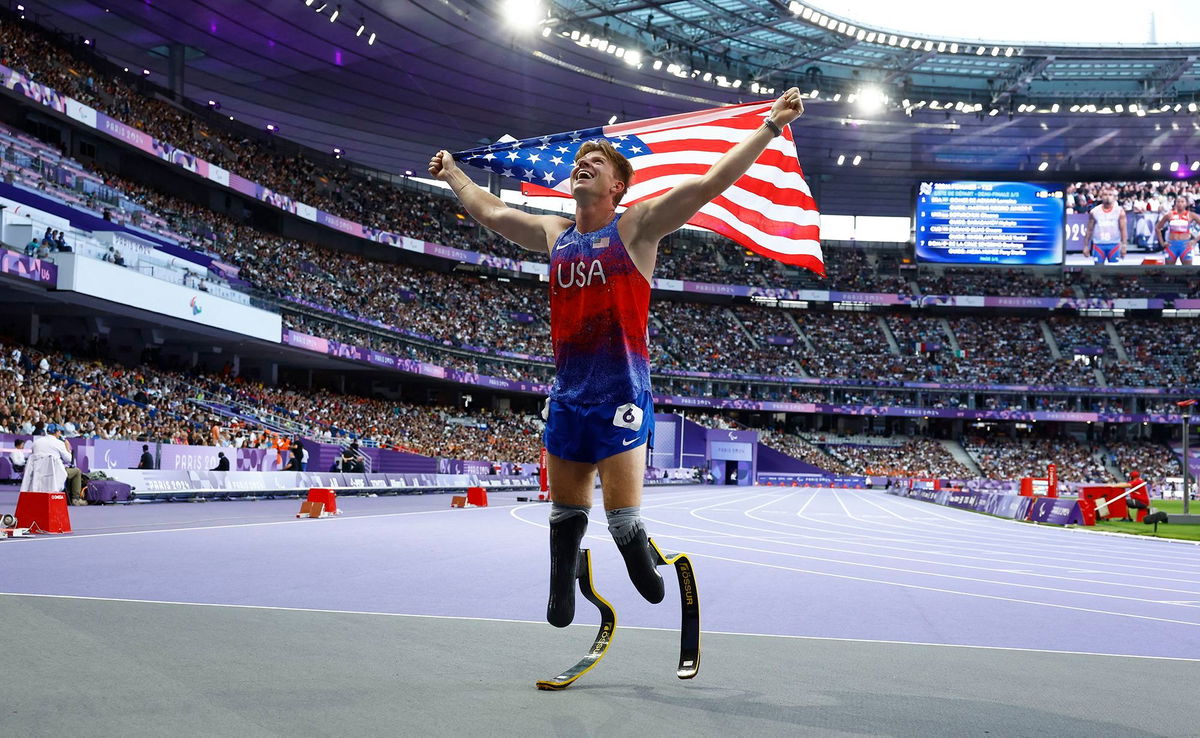 <i>Stephanie Lecocq/Reuters via CNN Newsource</i><br/>Team USA's Hunter Woodhall celebrates after winning gold at the Paris 2024 Paralympics.