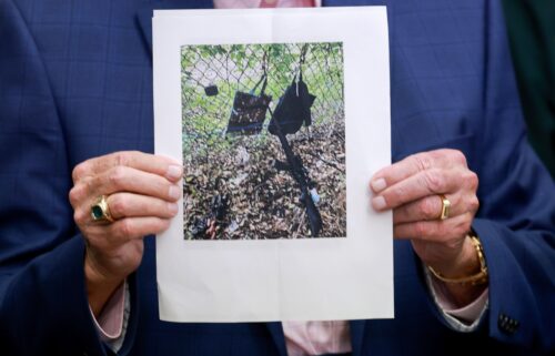 Palm Beach County Sheriff Ric Bradshaw holds a photograph of the rifle and other items found near where a suspect was discovered during a press conference on Sunday