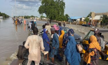 Residents leave the flooded areas with their belongings in Maiduguri