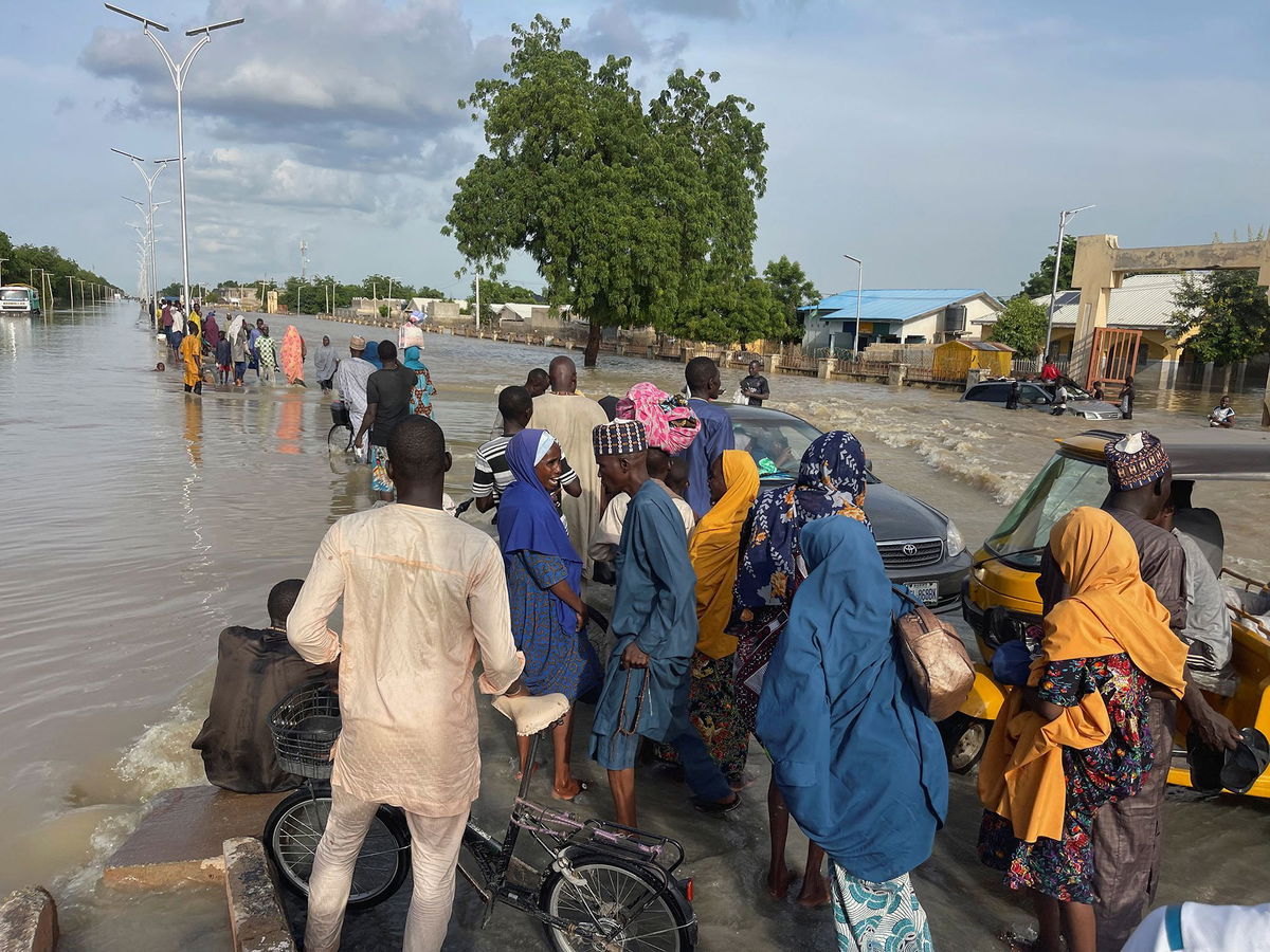 <i>Ahmed Kingimi/Reuters via CNN Newsource</i><br/>Residents leave the flooded areas with their belongings in Maiduguri