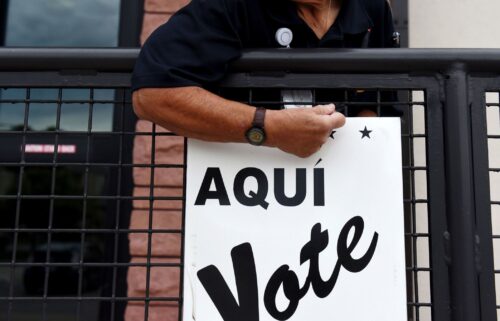 A Bexar County employee sets up signs during early voting at a polling location in San Antonio